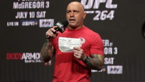 Joe Rogan speaking at UFC 264, wearign a red t-shirt.